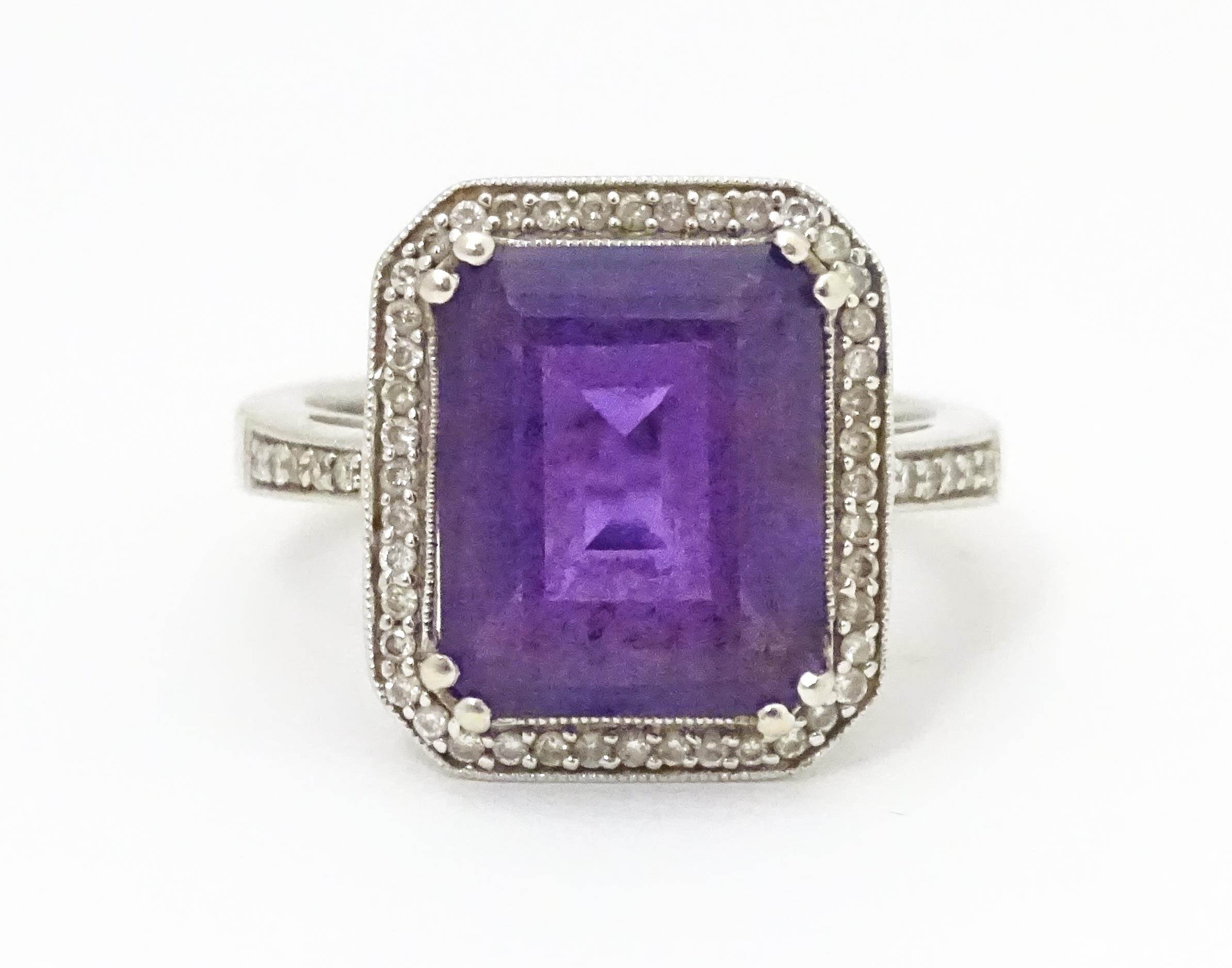 An 18ct gold ring set with central amethyst bordered by diamonds with further diamonds to shoulders. - Image 7 of 8