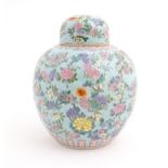 A Chinese ginger jar with a light blue ground decorated with flowers and foliage, with pink