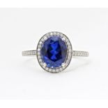 A silver ring set with central blue stone bordered and flanked by cubic zirconia. Ring size