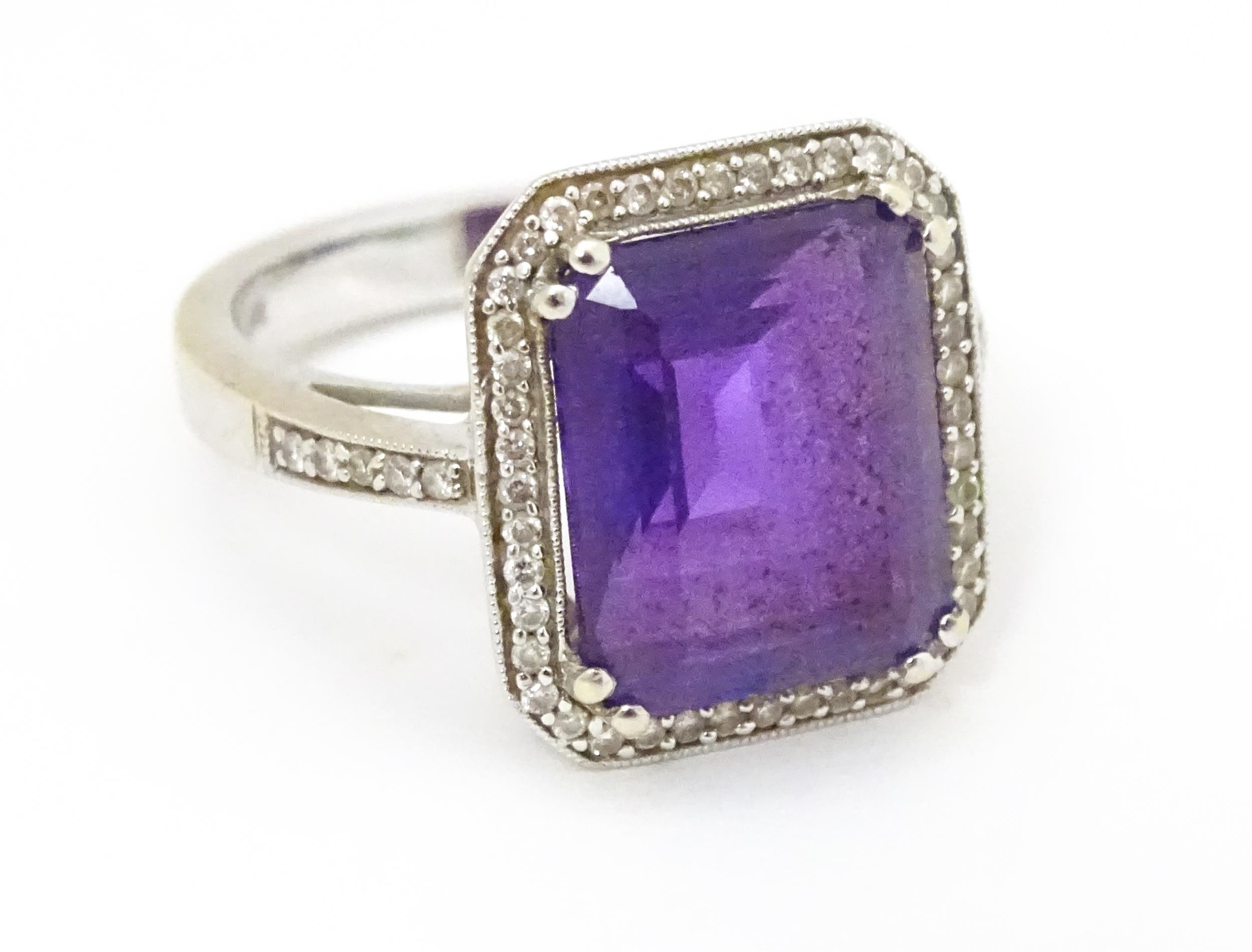 An 18ct gold ring set with central amethyst bordered by diamonds with further diamonds to shoulders. - Image 8 of 8