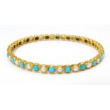 A yellow metal bracelet of bangle form set with turquoise and pearl