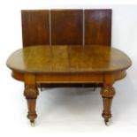 A 19thC dining table with an oval table top above four carved legs decorated with anthemion motifs