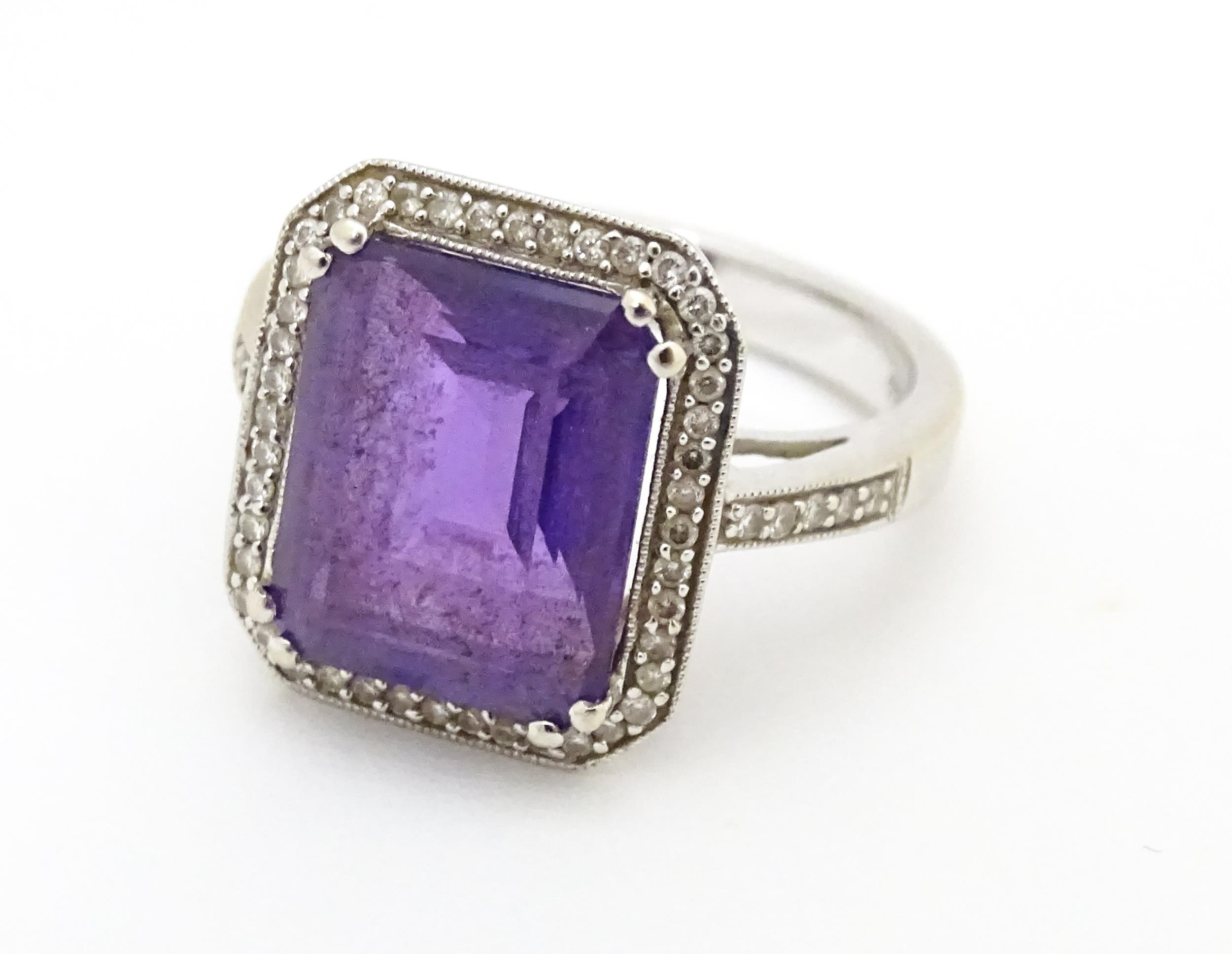 An 18ct gold ring set with central amethyst bordered by diamonds with further diamonds to shoulders. - Image 6 of 8