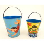 Two vintage tin seaside buckets with swing handles, decorated with children playing. Largest approx.