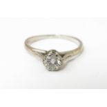 A white metal ring set with central diamond solitaire. Diamond approx. 1/8" diameter Ring size