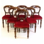 A set of six 20thC mahogany balloon back dining chairs with carved mid rails, red upholstered