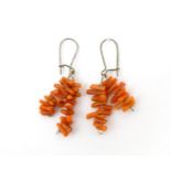 A pair of drop earrings set with coral. Approx. 1 1/4" long Please Note - we do not make reference