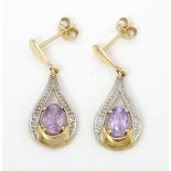 Yellow metal drop earrings set with amethyst and chip set diamonds. Approx 1" long Please Note -