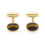 A pair of 15ct gold cufflinks set with tigers eye cabochon Please Note - we do not make reference to