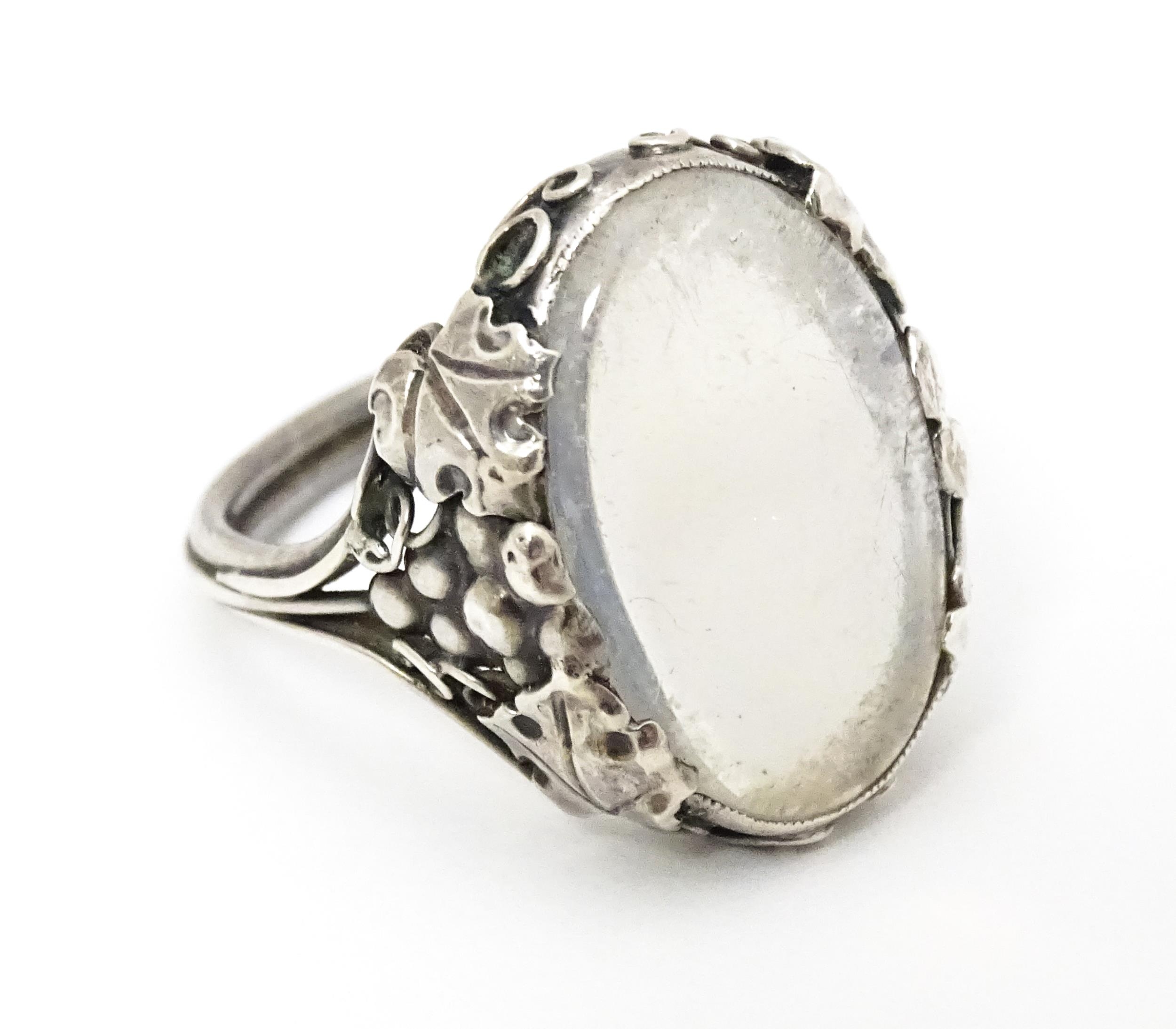 A white metal ring set with central oval moonstone cabochon and with fruiting vine detail to - Image 6 of 6