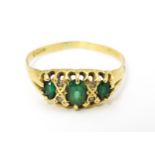 An 18ct gold ring set with green and white stones. Ring size approx. V Please Note - we do not