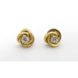 A pair of 9ct gold stud earrings set with white stones Please Note - we do not make reference to the