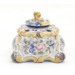 A Continental faience inkwell of shaped form with hand painted floral and foliate decoration.