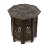 An early 20thC ottoman style table with an octagonal table top and base with carved fruiting vine