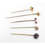 Five assorted gold and yellow metal stick pins to include 9ct and 15ct gold examples, and set with