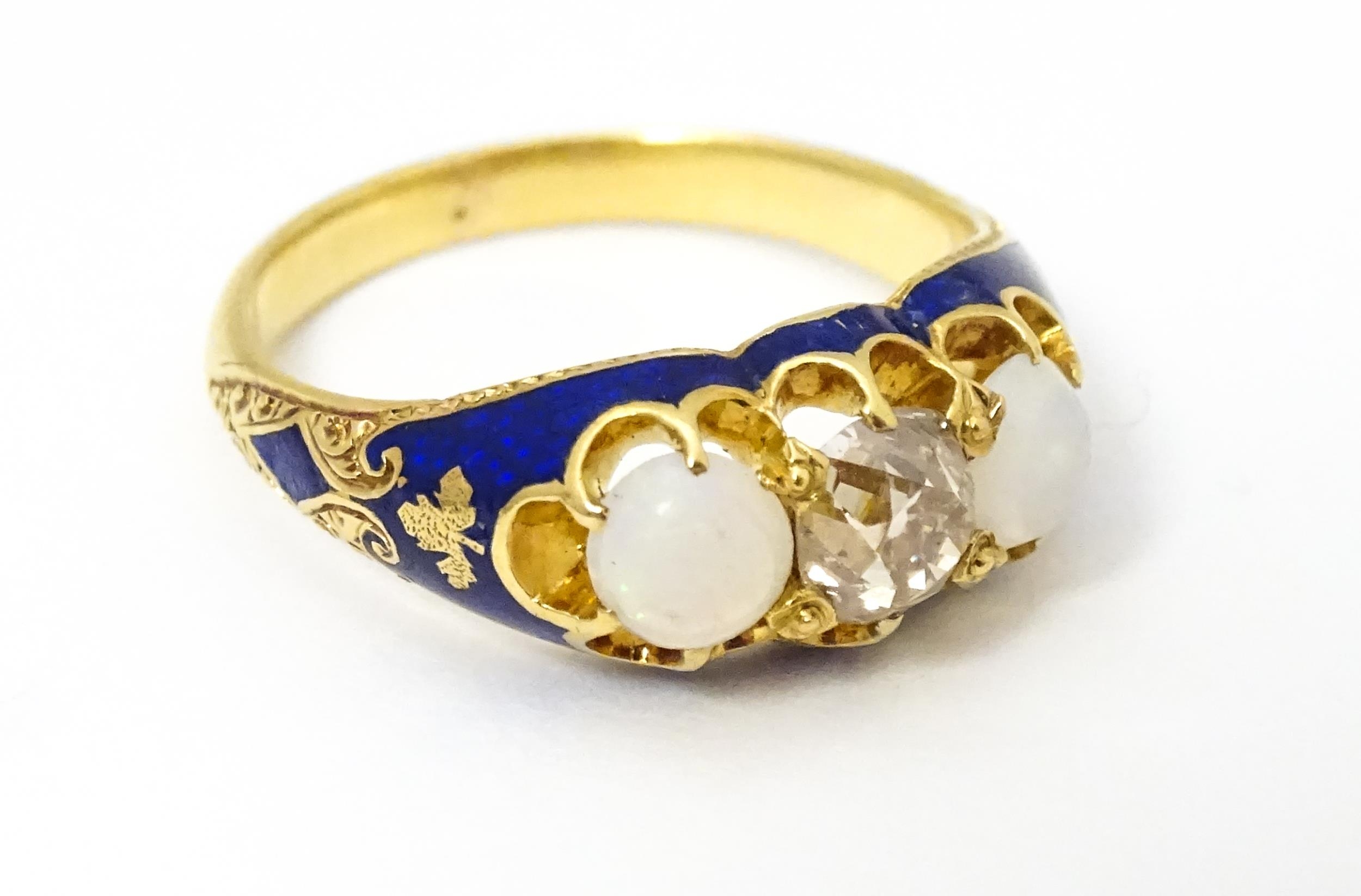 A 19thC yellow gold ring set with central diamond flanked by opals in a blue enamel setting. Ring - Image 2 of 4