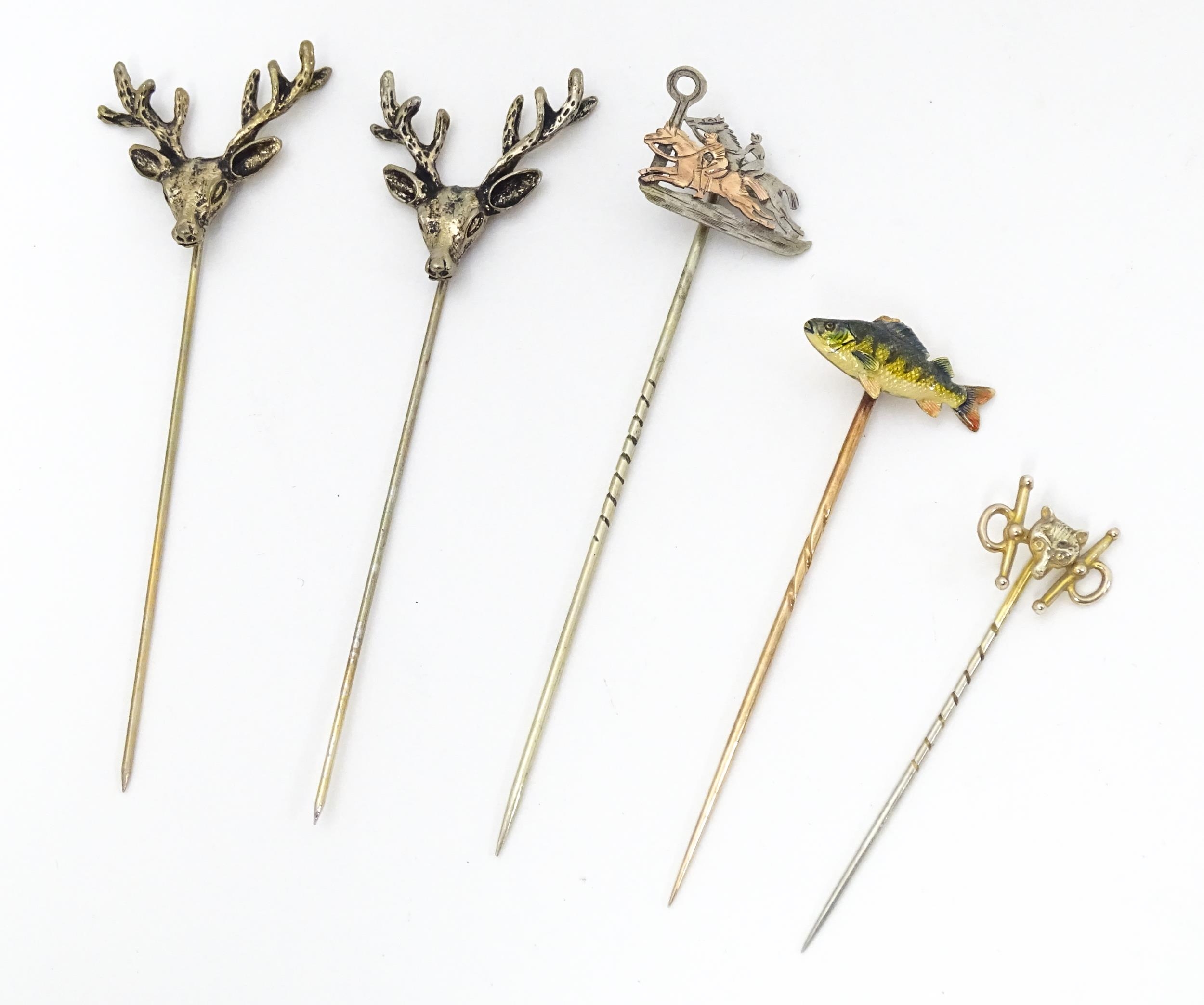 Five assorted yellow and white metal stick pins to include two decorated with stag head detail,