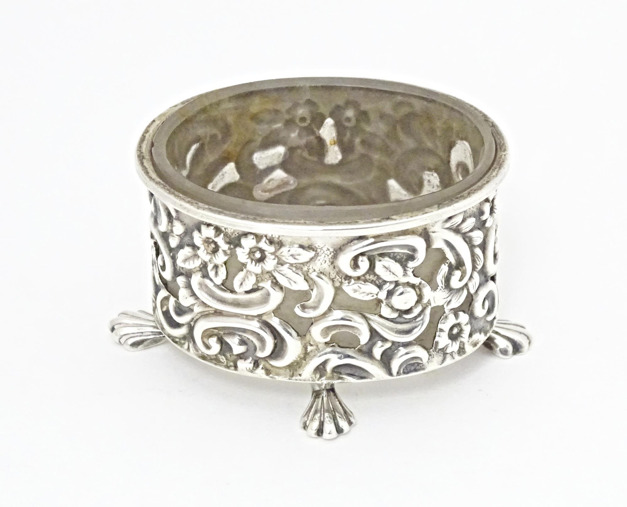 A Victorian silver salt of oval form with embossed decoration and four stylised paw feet, and