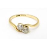 An 18ct gold ring with two platinum set round cut diamonds. Ring size approx. M Please Note - we