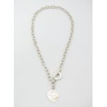 A silver necklace with heart shaped fob engraved '.. Tiffany & Co...' . Approx. 18" long Please Note