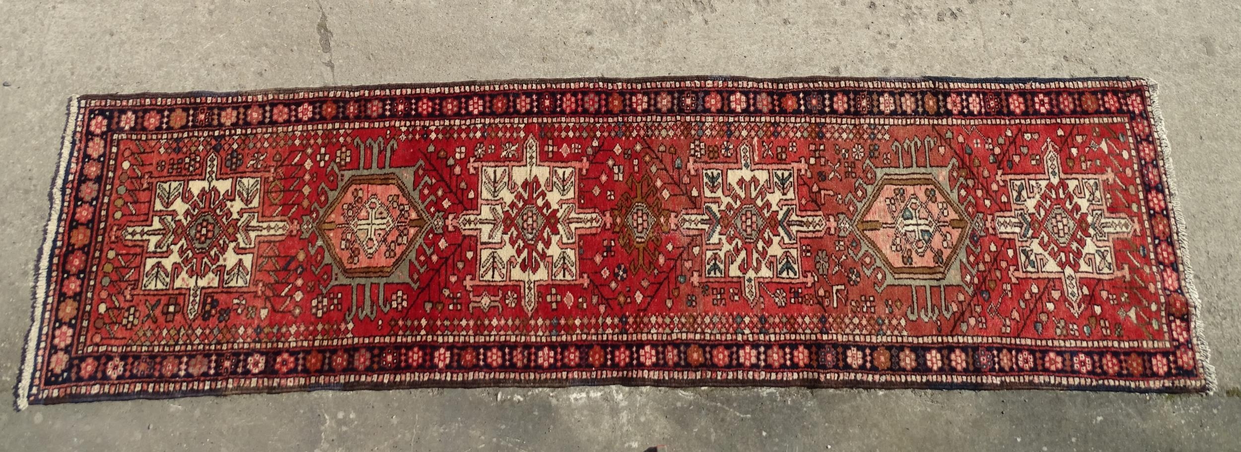 Carpet / Rug : A North West Persian Heriz runner with red ground having central medallions with