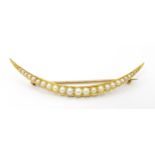A Victorian gild brooch of crescent form set with graduated pearls. In fitted case marked Wales &