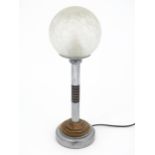An Art Deco steel and brass table lamp with a spherical glass shade, approx 18" high Please Note -