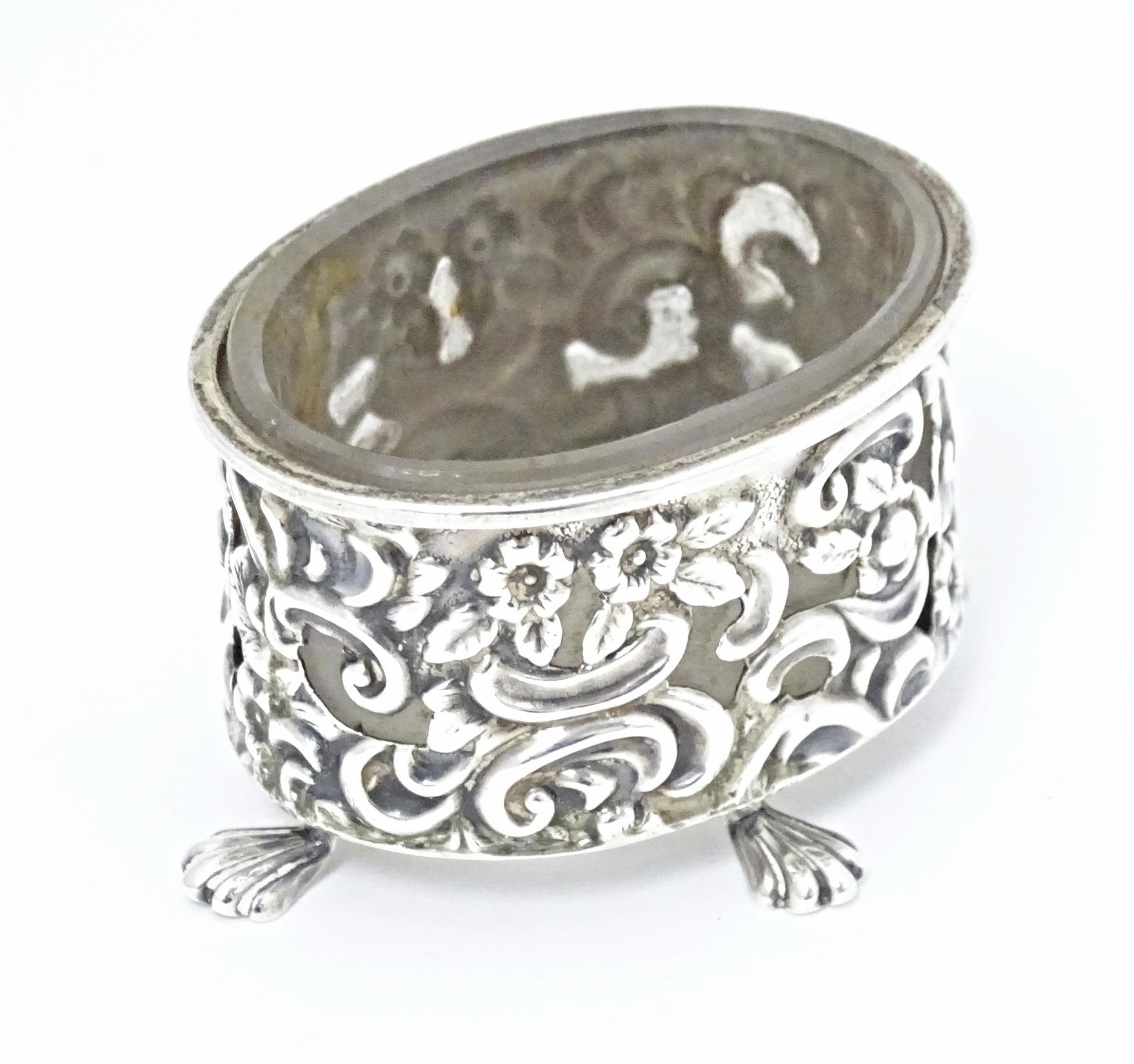 A Victorian silver salt of oval form with embossed decoration and four stylised paw feet, and - Image 3 of 7