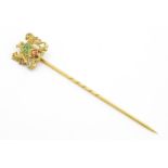 A 9ct gold stick pin surmounted by an armorial crest for the Worshipful Company of Clothworkers with