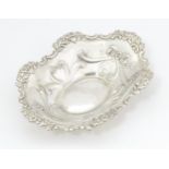 A silver bonbon dish of oval form with embossed decoration, hallmarked Birmingham 2002 with