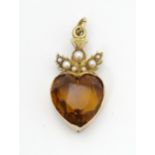 A Victorian yellow metal pendant set with heart shaped citrine surmounted by thistle detail set with