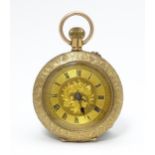 A ladies 9ct gold cased fob watch with engraved floral and scroll decoration. Bearing early 20thC