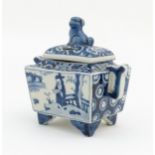A Chinese blue and white twin handled censer raised on four shaped feet, decorated with figures in a