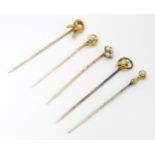 Five assorted gold and gilt metal stick pins set with seed pearls, to include an example stamped