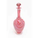 A Victorian cranberry and white glass Nailsea style decanter and stopper, with clear glass foot.