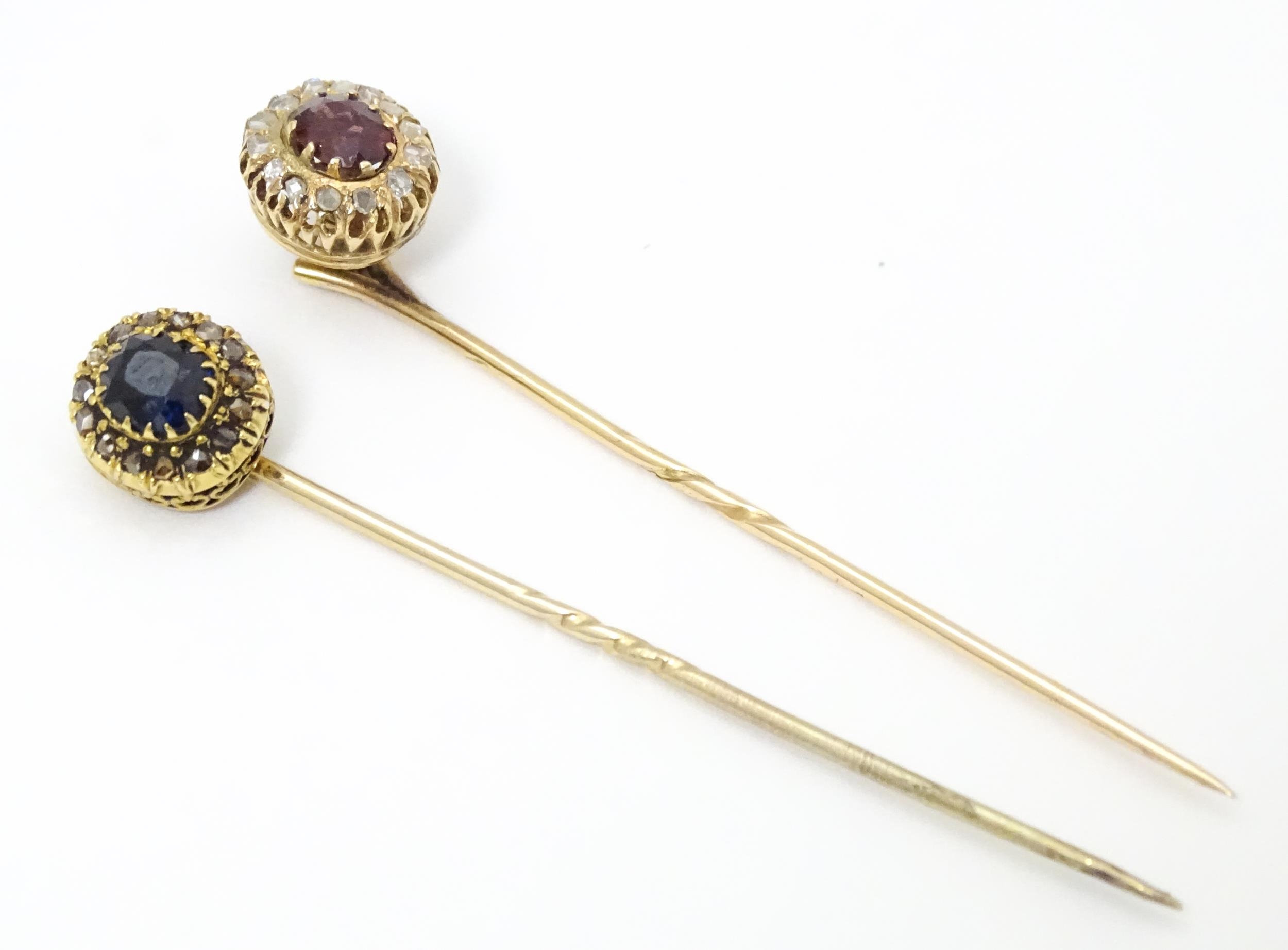 Two yellow metal stick pins, one surmounted by a central sapphire bordered by diamonds, the other - Image 2 of 6