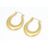 A pair of yellow metal hoop earrings, Approx. 1" long Please Note - we do not make reference to