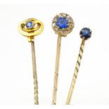 Three gold and yellow metal stick pins set with sapphires, including an example set with sapphires