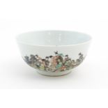 A Chinese famille rose bowl decorated with a landscape scene with figures on horseback. Character