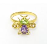 A silver gilt ring with bee / winged insect decoration set with amethyst, pearl and peridot. Ring