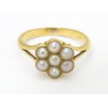 A yellow metal ring set with seed pearls. Ring size approx. M 1/2 Please Note - we do not make