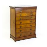 A 19thC walnut chest of drawers in the Neo-Gothic style, with a rectangular top above seven
