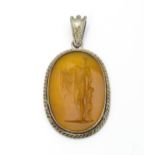 A white metal pendant of oval form set with central intaglio depicting Apollo Belvedere. Approx. 1