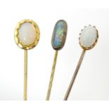 Three gilt metal stick pins set with opal cabochon. The longest 2 1/2" long (3) Please Note - we