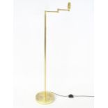 A brass standard lamp with adjustable arm. Approx 54" high Please Note - we do not make reference to