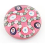 A 19thC trefoil garland millefiori paperweight, the pink ground with loops of trefoil garland and