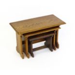 An oak Cotswold school nest of tables with carved edges, shaped supports and H - stretchers. 28"
