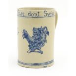 A tankard with hand painted decoration depicting a rampant lion and the motto Drink Faire Dont
