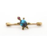 A yellow metal brooch with tortoise to centre set with turquoise and ruby. 1 3/4" wide Please Note -