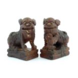 Two Chinese carved wooden foo dogs / guardian lions, one with a cub, the other with a ball, with